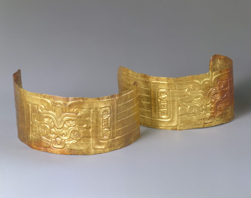 Pair of ancient gold cuffs with embossed ceremonial face motifs